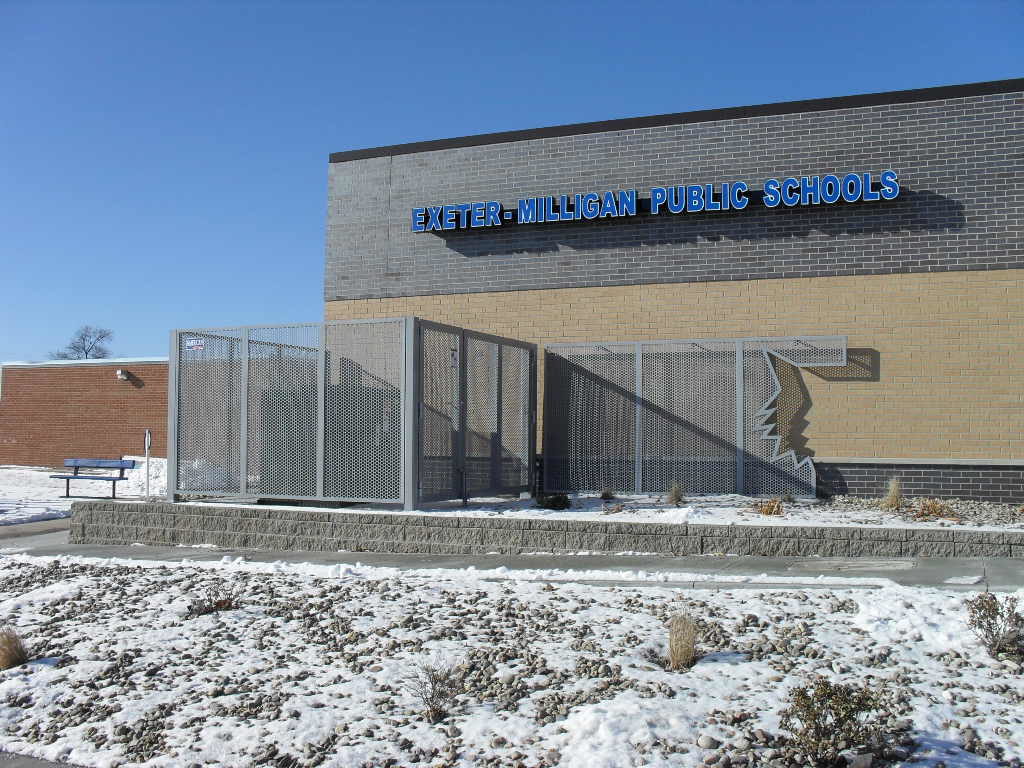 A custom perforated panel enclosing a heating and cooling system outside of a school district building